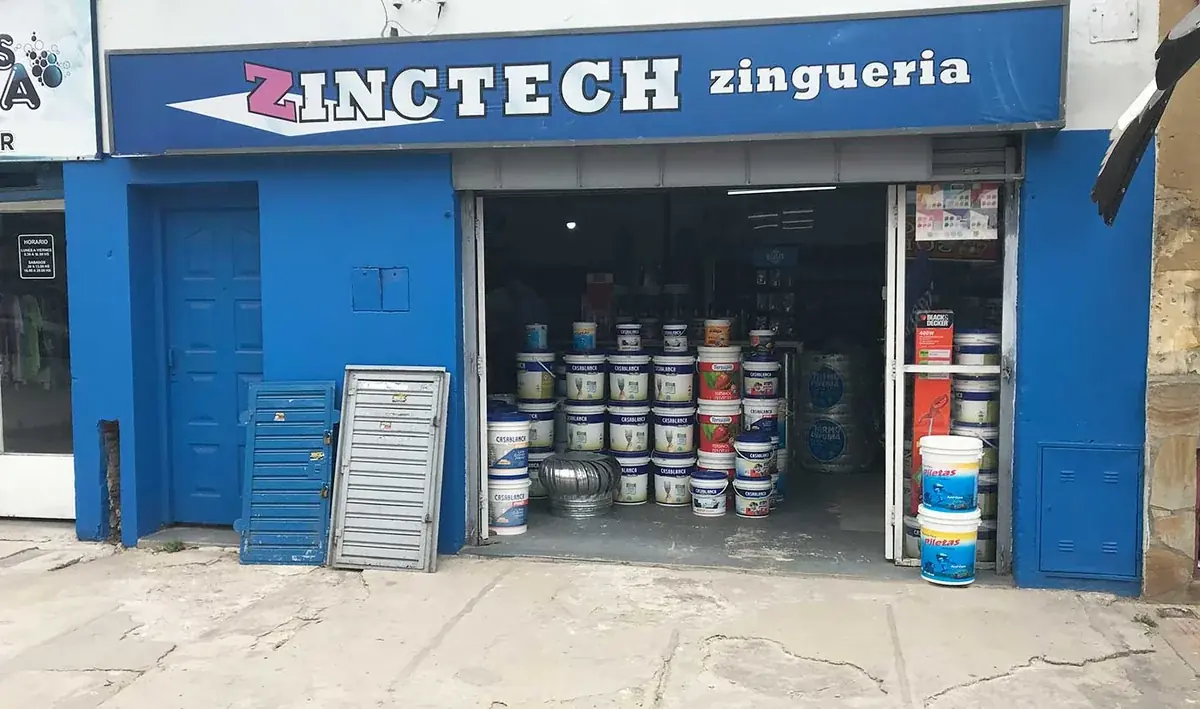 El frente del local, pintado de azul, con el cartel de Zinctech sobre la vereda.