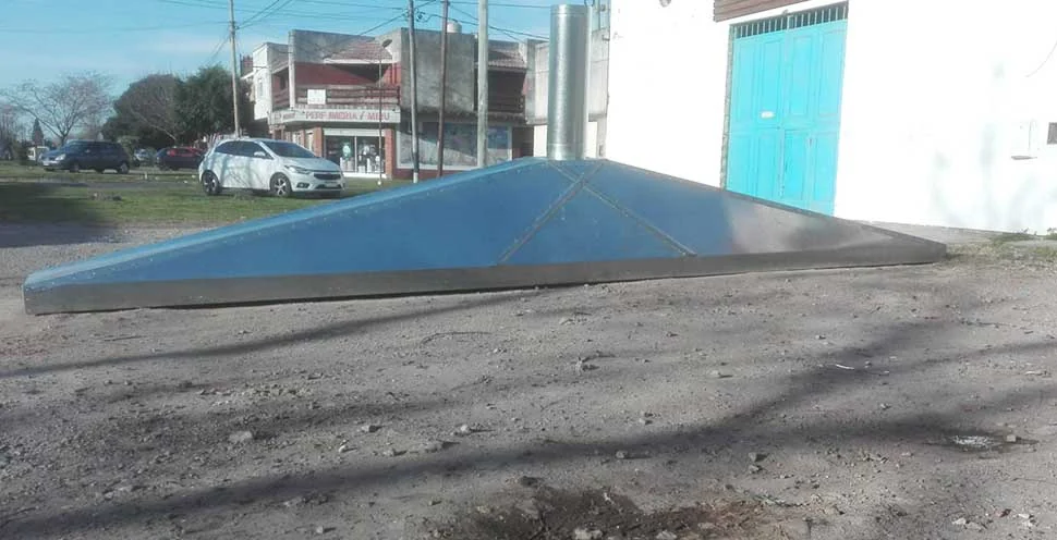 Claraboya triangular de chapa galvanizada, terminada, sobre la vereda.
